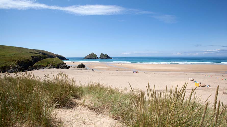 A view over Holywell Bay Beach in Cornwall on a sunny day