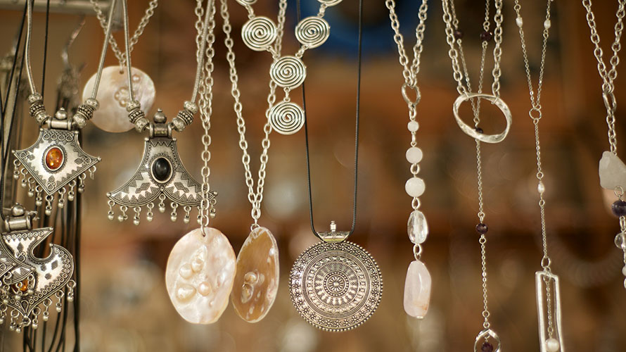 A display of handmade necklaces hanging in a row