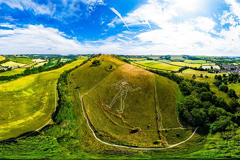 An aerial view of the Cerne Abbas Giant amongst the rolling hills of the Dorset countryside