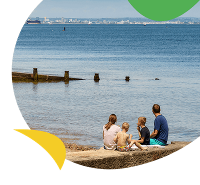 A family sitting on a pier on the Isle of Wight