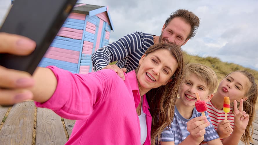 A family taking a selfie at the beach