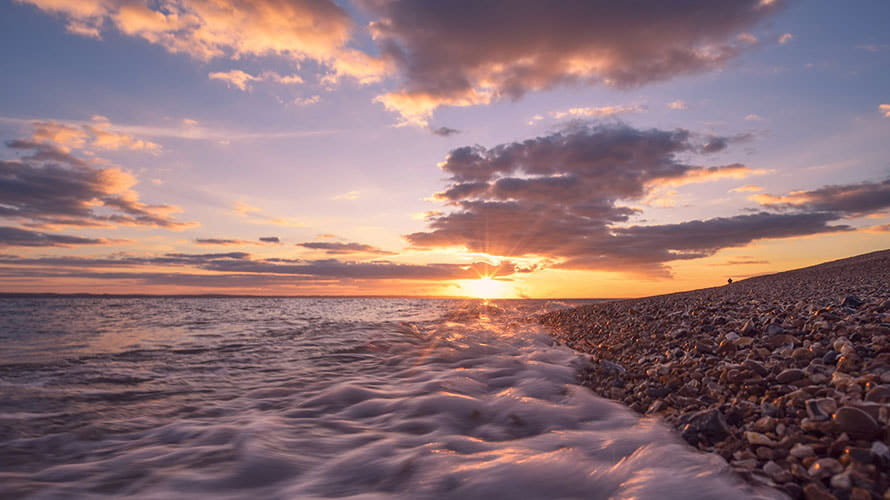 Sunset over a pebble beach