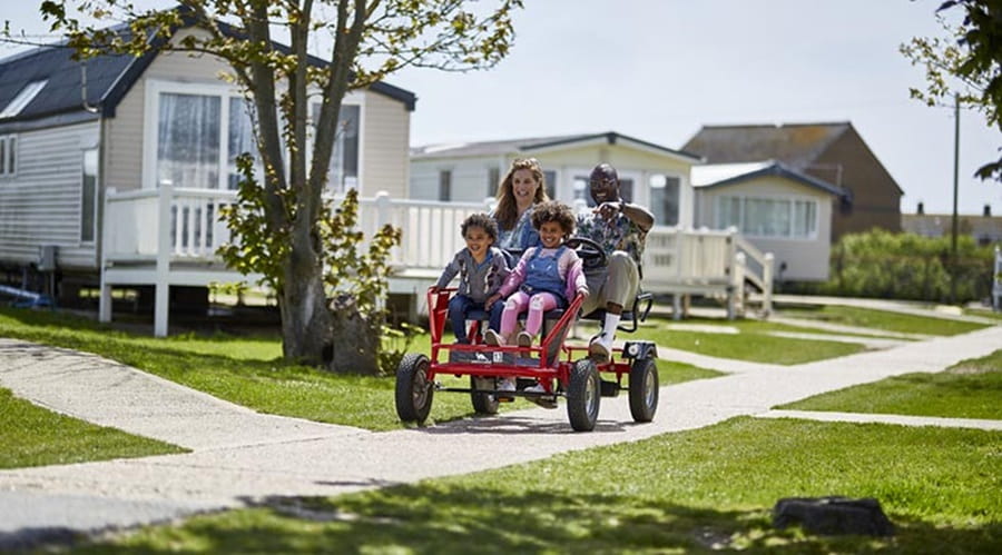 A family enjoying riding a family kart at camber sands holiday park