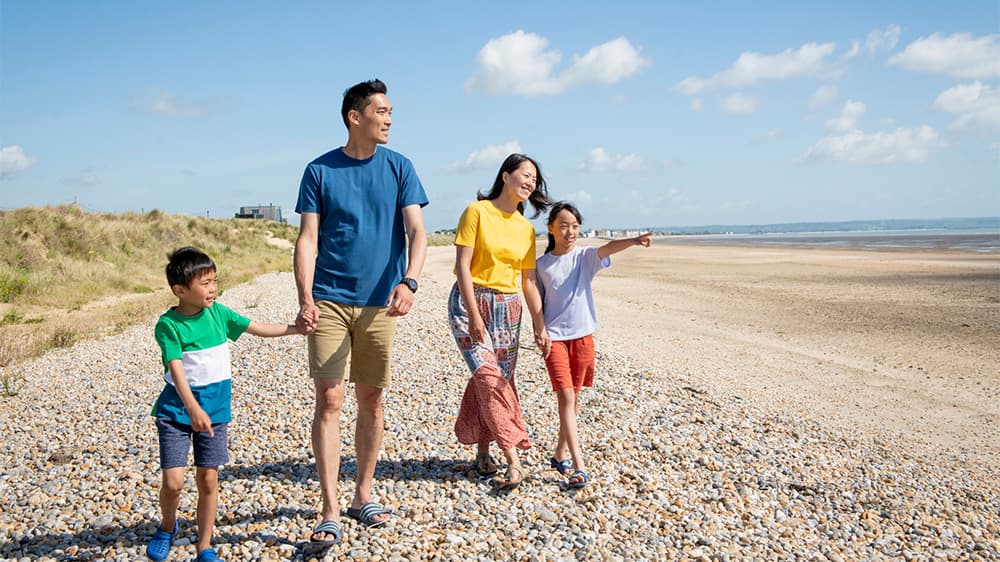 A family walking along a beach on a sunny day