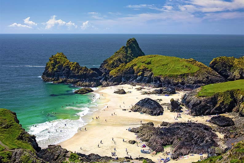 Families enjoying the beach on a sunny day at Kynance Cove