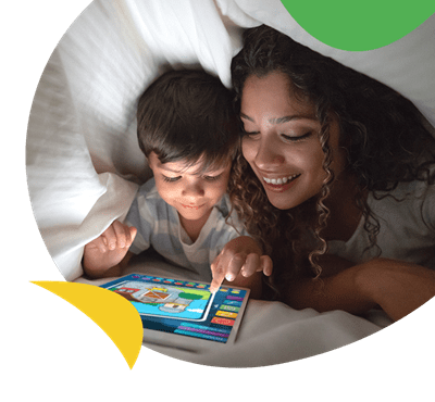Mum and son sat under duvet watching an iPad
