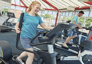 People using the cross trainer and treadmill in the gym