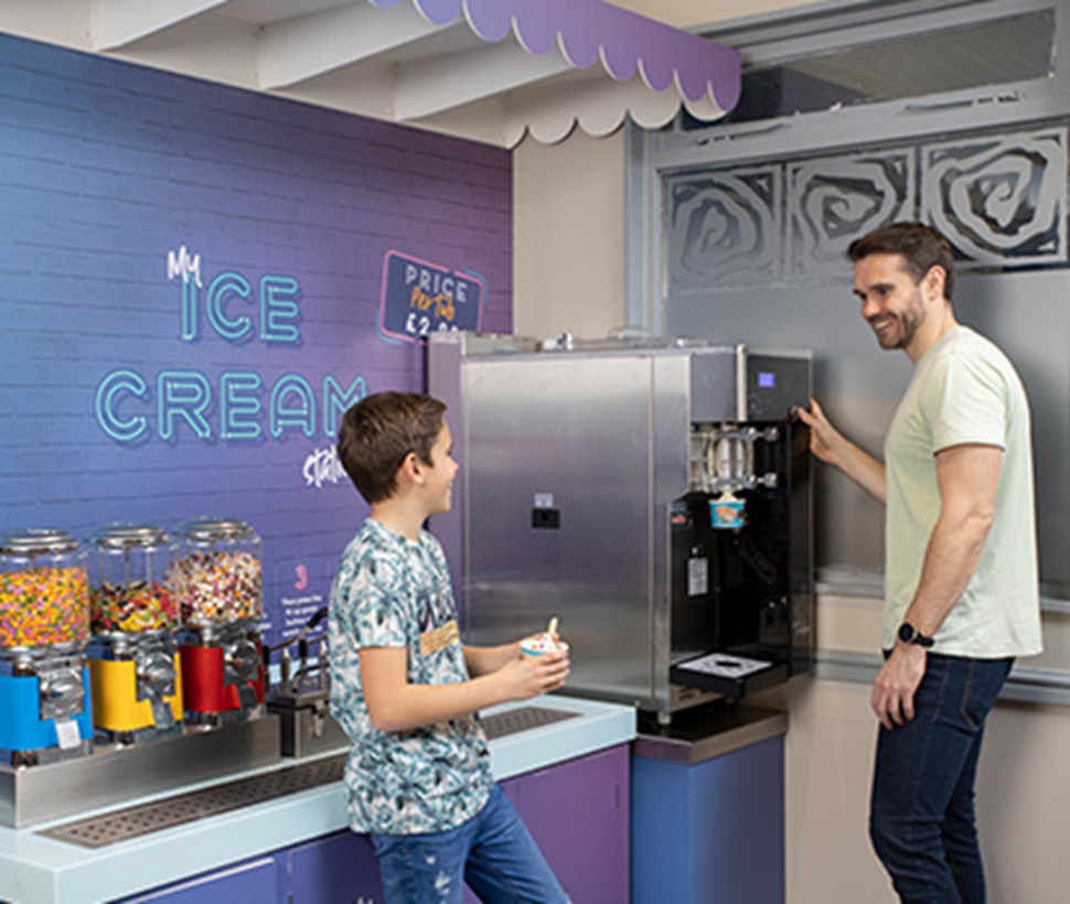 father and son at the ice cream station in the restaurant
