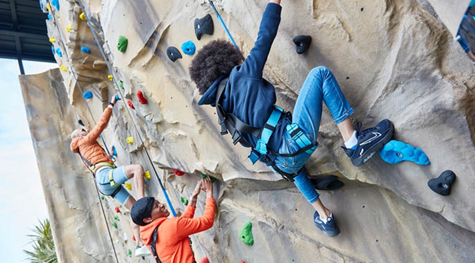 people climbing up a climbing wall