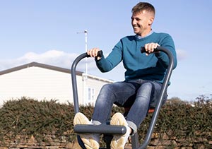A man using the outdoor gym equipment