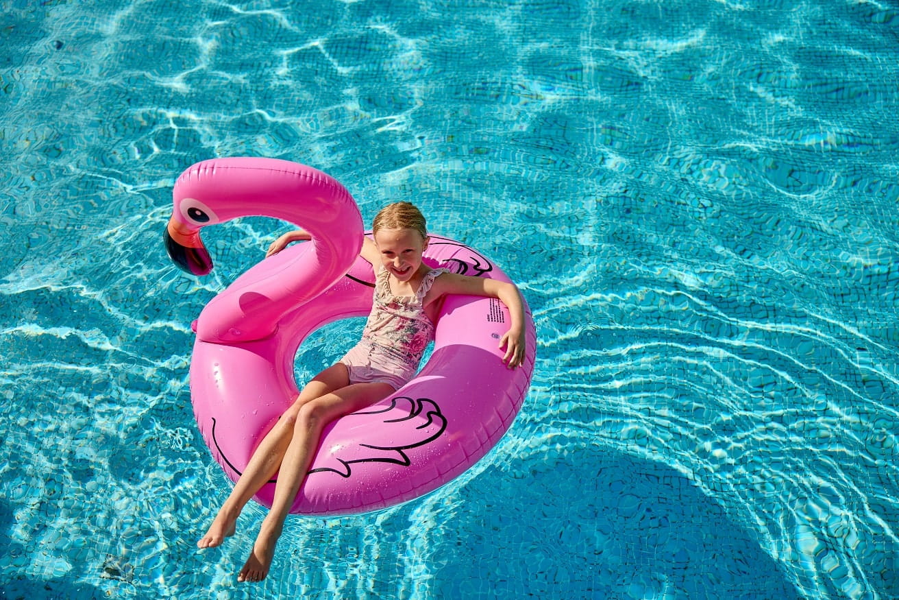 child on inflatable flamingo