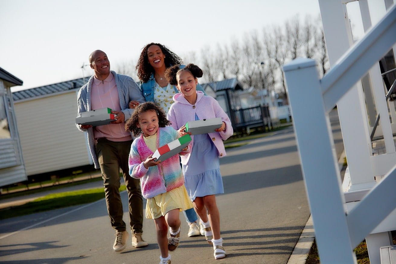 family taking a takeaway back to their caravan