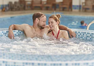 A couple relaxing in the spa bath at the indoor swimming pool