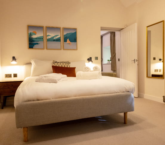 Double bed with white bedding and grey headboard
