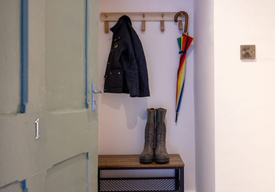 Sage green door with number 1 looking into a boot room