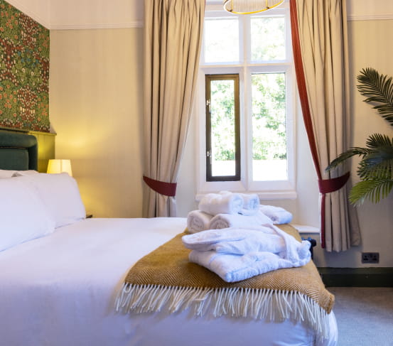 Double bed with white bedding and mustard throw