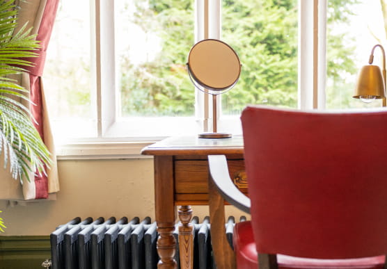 Red arm chair sat with a wooden desk in the window