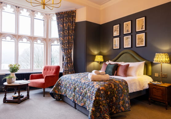 King size bedroom with green headboard and patterned throw
