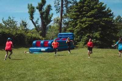 People playing on inflatable and running