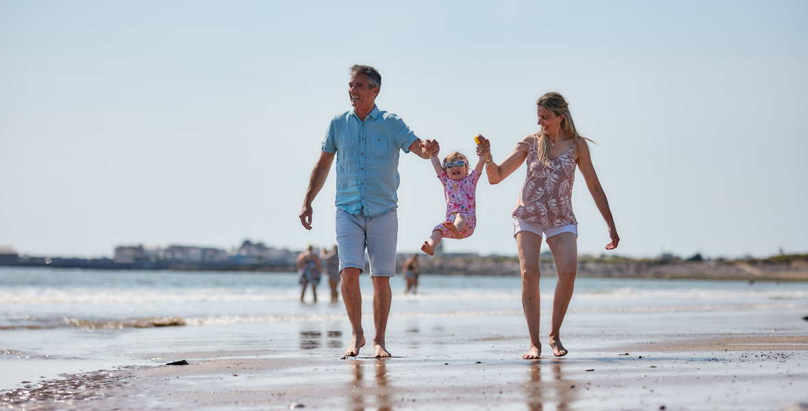 Family walking on sunny UK beach