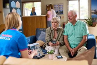 A couple discussing caravan running costs with a sales advisor at Parkdean Resorts