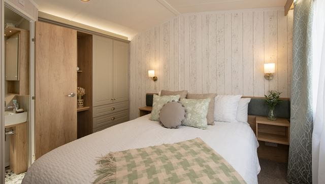 Double bedroom with fitted wardrobes and white bedding