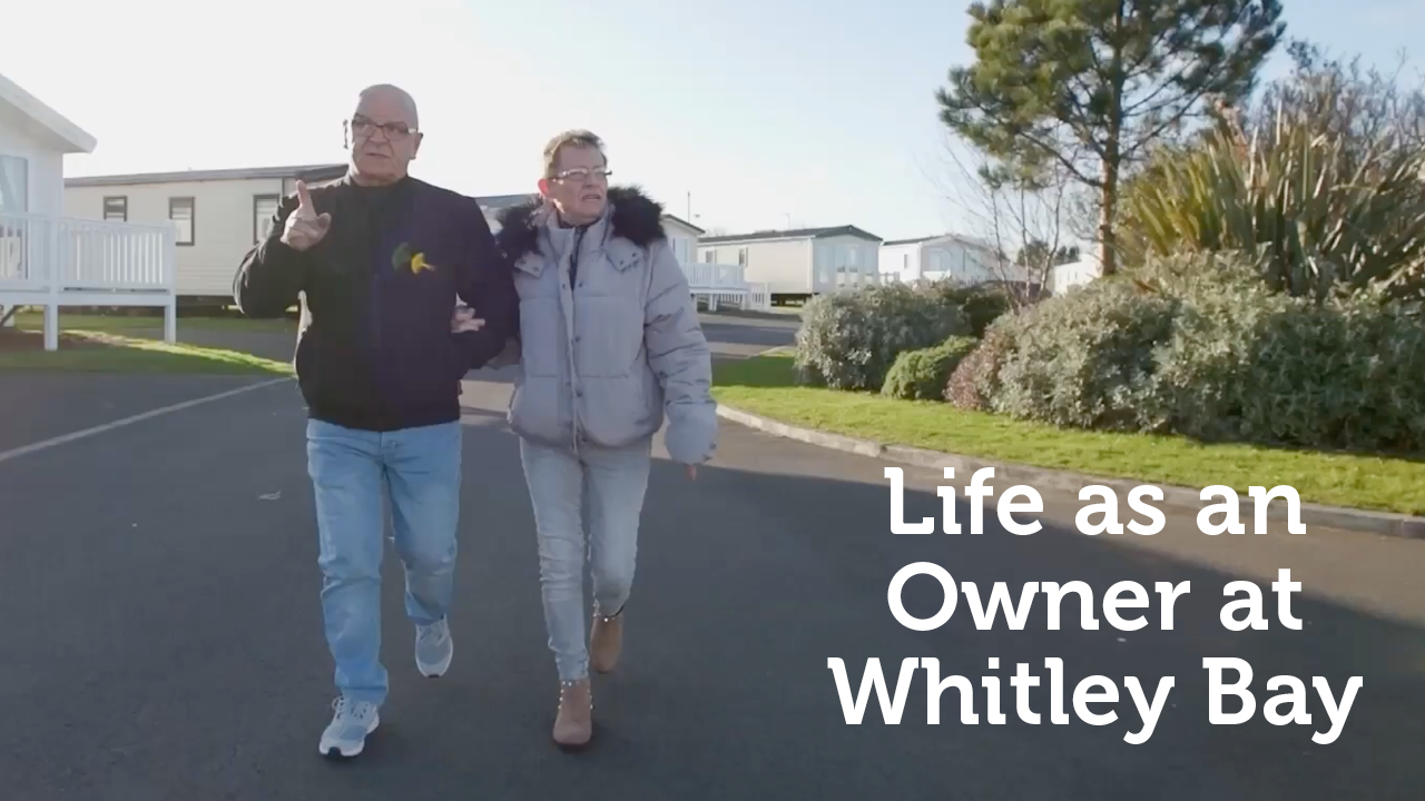 Couple walking arm in arm at Whitley Bay