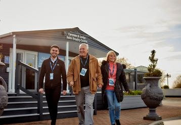 a couple walking out of the holiday home sale office with a sales advisor