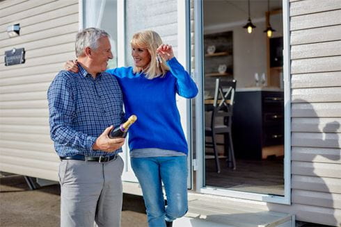 A couple holding the keys to their first used holiday home