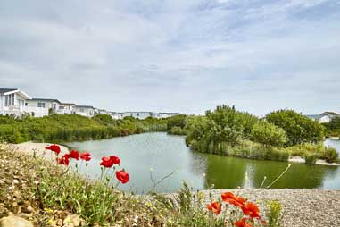 Caravans and holiday homes overlooking a fishing lake in Kent and Sussex