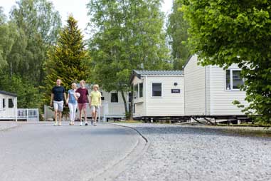 A family walking past a row of holiday homes in Scotland