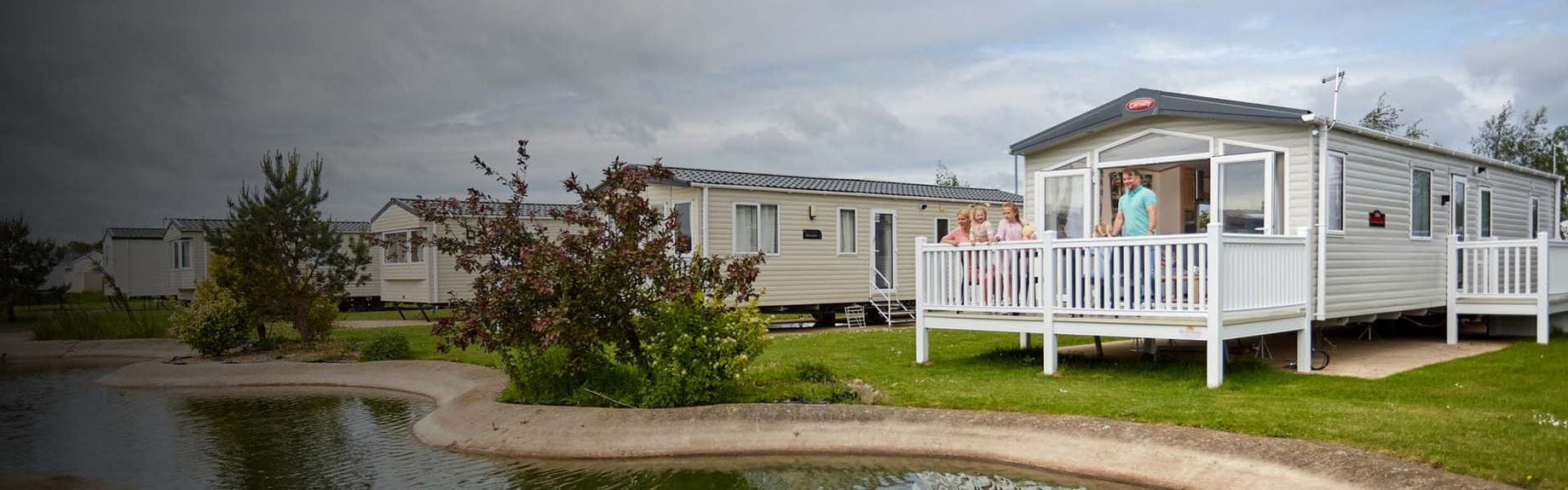 A family on the veranda of their static caravan holiday home