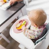 A baby eating lunch in a high chair