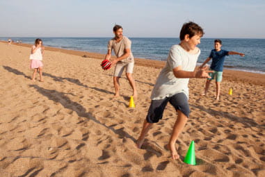 family playing beach games by the sea