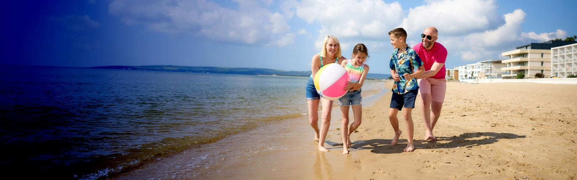 A family walking down the beach on a sunny day