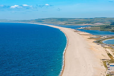 An aerial view over a long beach in Dorset