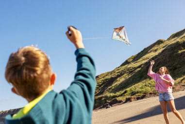 kids flying kites to each other