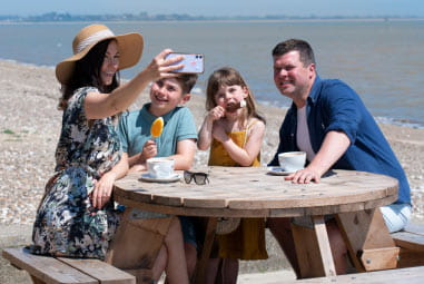 family having a picnic on a table by the sea