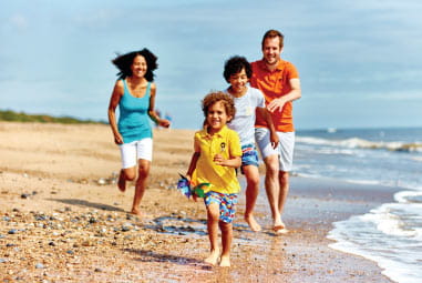 family laughing together on a picturesque beach