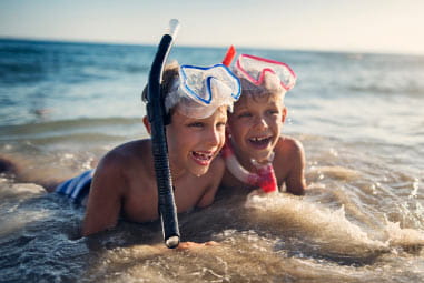 kids with snorkels on by the sea