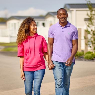 couple holding hands at a sunny caravan park