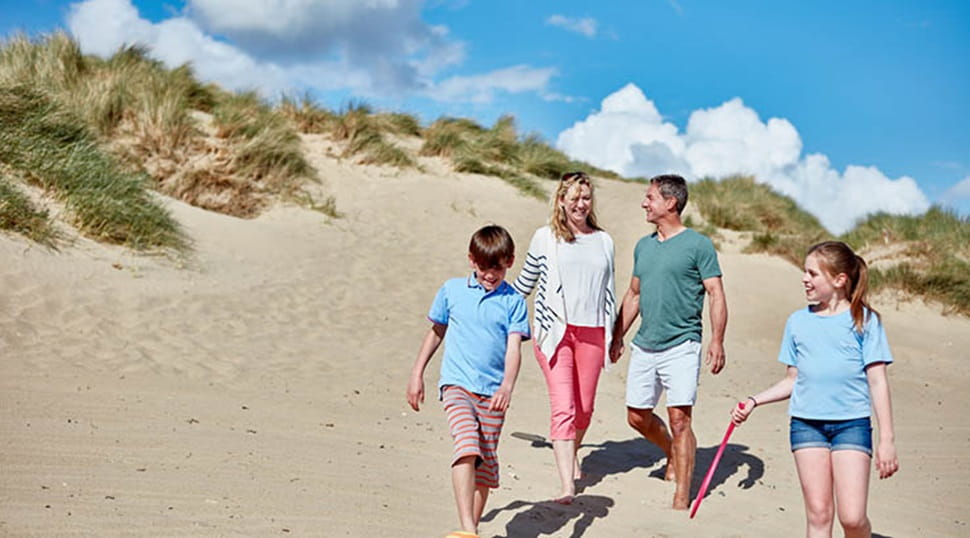 a family walking down sand dunes