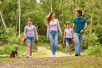 Family walking with dog through woods