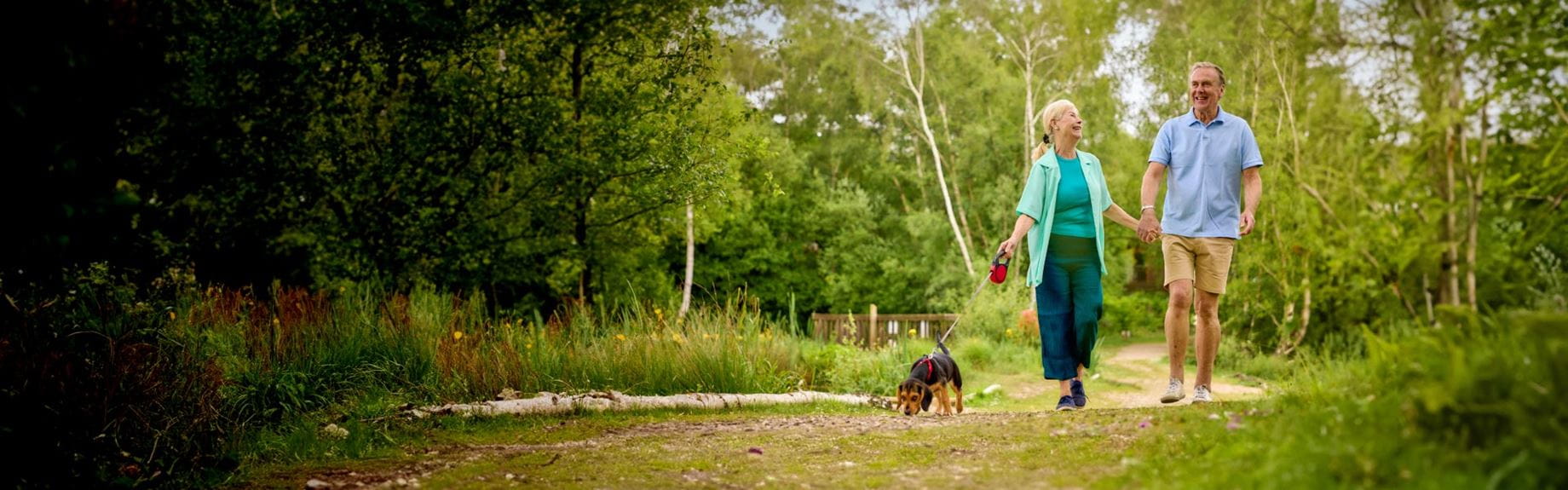 Man and woman walking dog in woods