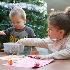 two children doing crafts at a table