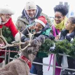 a family in front of a reindeer
