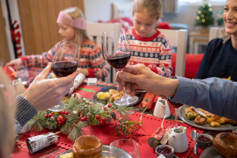 Family sat around the table enjoying Christmas dinner