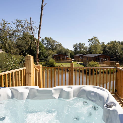 A hot tub on a lodge veranda at Warmwell Holiday Park