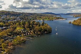 An aerial view of Lake Windermere showing Fallbarrow holiday park and its lakeside lodges