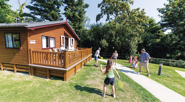 A family playing outside their holiday lodge on the Isle of Wight